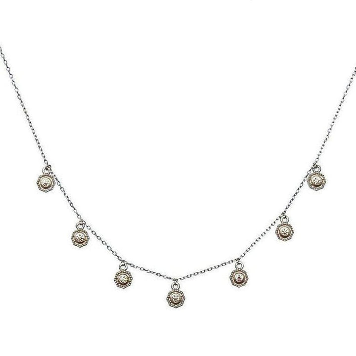 Mini Crystals silver necklace with delicate chain and seven small, ornate pendants.
