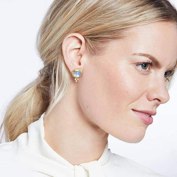 Gold stud earrings featuring a light blue gemstone and small pearl accents.
