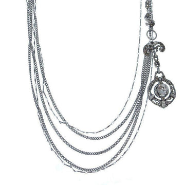 Silver multi-strand necklace with ornate pendant and clear cabochon stone.

