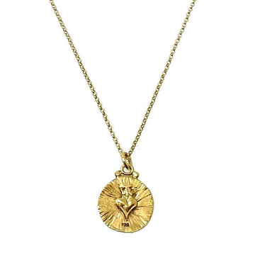 Gold necklace featuring a circular charm with a heart-shaped design.
