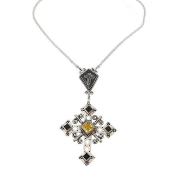Silver cross necklace with black and yellow gemstones, intricate detailing.
