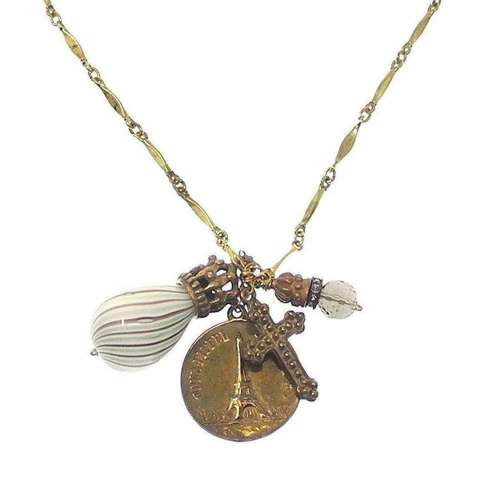 Gold chain necklace with Eiffel Tower, cross, and glass charm pendants.
