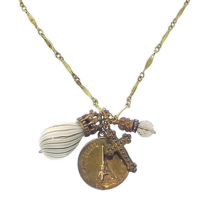 Gold chain necklace with Eiffel Tower, cross, and glass charm pendants.
