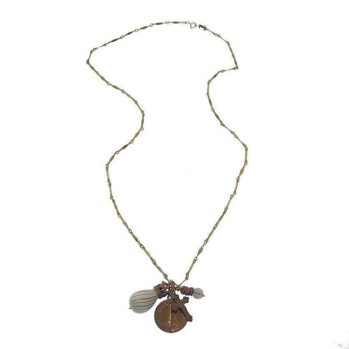 Gold chain necklace featuring a Paris medallion, cross charm, and glass bead accents.
