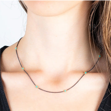 Oxidized sterling silver chain necklace featuring stationed turquoise stones set in 18k gold accents.