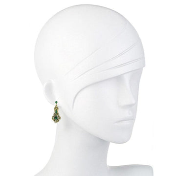 Green and gold drop earrings on a mannequin.
