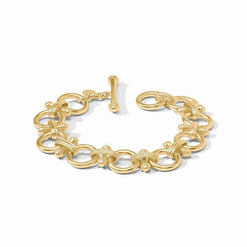 Gold statement bracelet with interlocking circular links and a toggle clasp.
