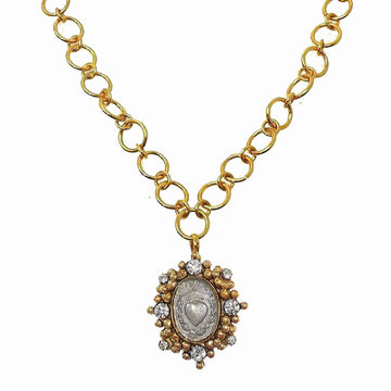Gold chain necklace featuring a silver heart charm accented with sparkling crystals.
