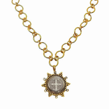 Gold chain necklace featuring a circular pendant with tiny gemstones.
