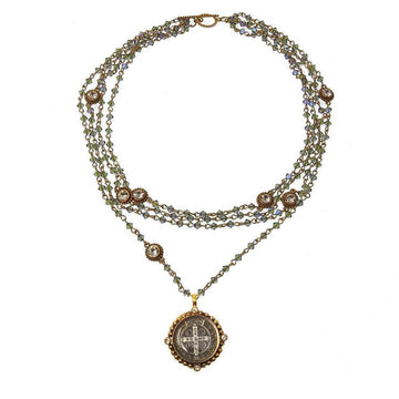 Layered metallic blue crystal necklace with a St. Christopher medal pendant.
