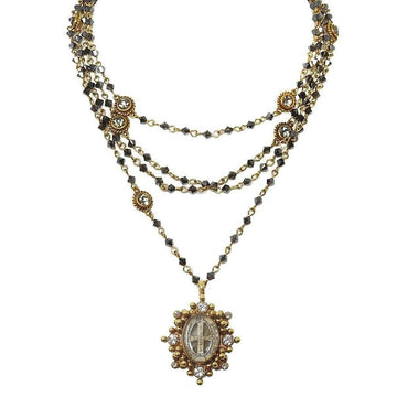 Layered gemstone necklace with antique-style pendant.
