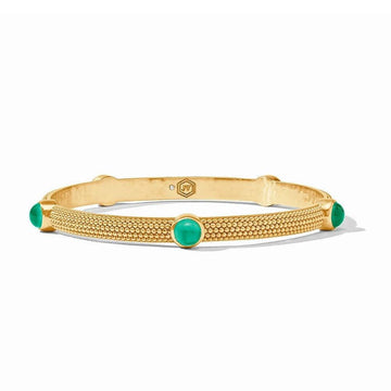 Gold cabochon bangle with green gemstones, textured band.
