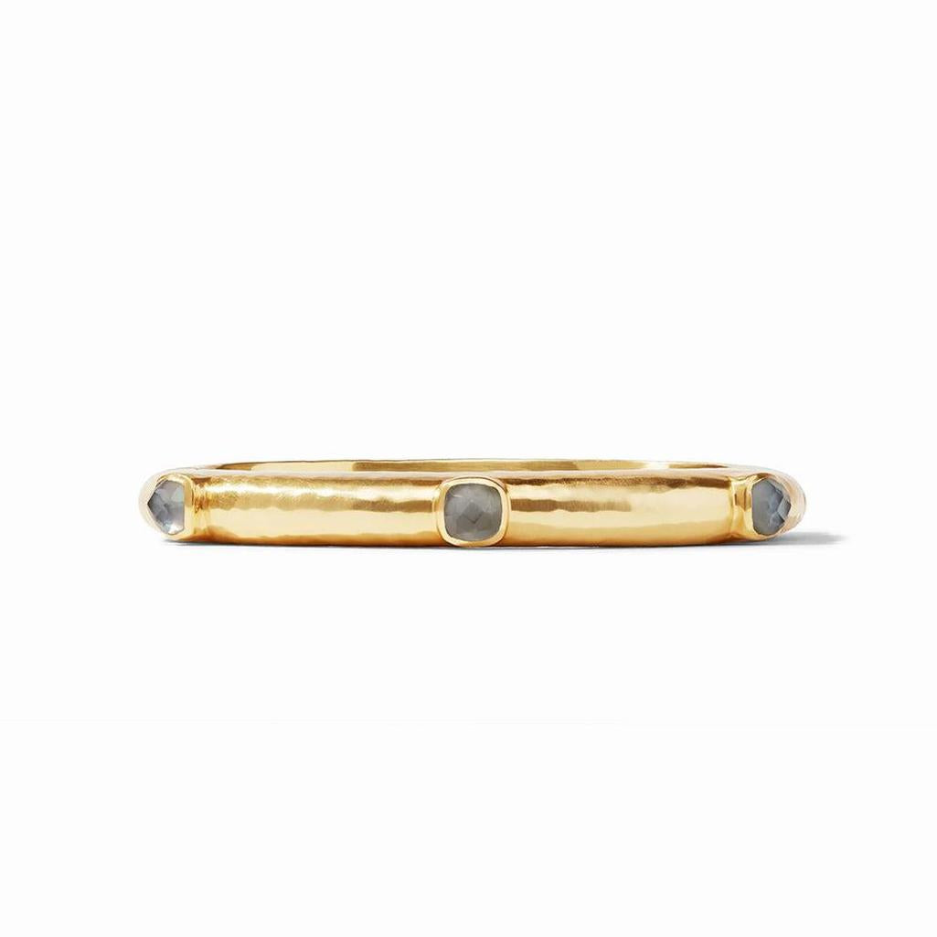 Gold hinged bangle with gray gemstones.
