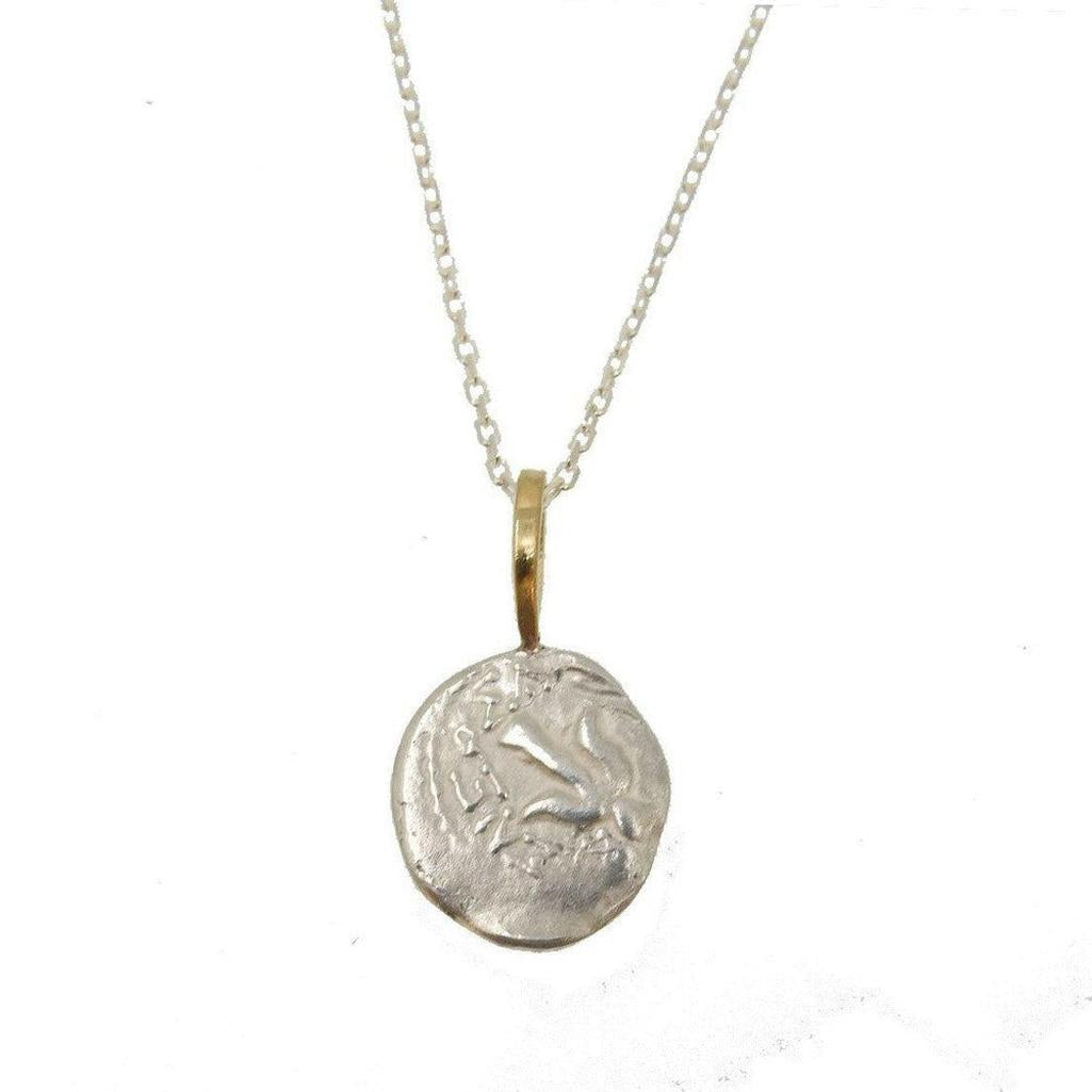 Silver Gratitude Star necklace with gold bail, featuring an antique coin-inspired pendant.
