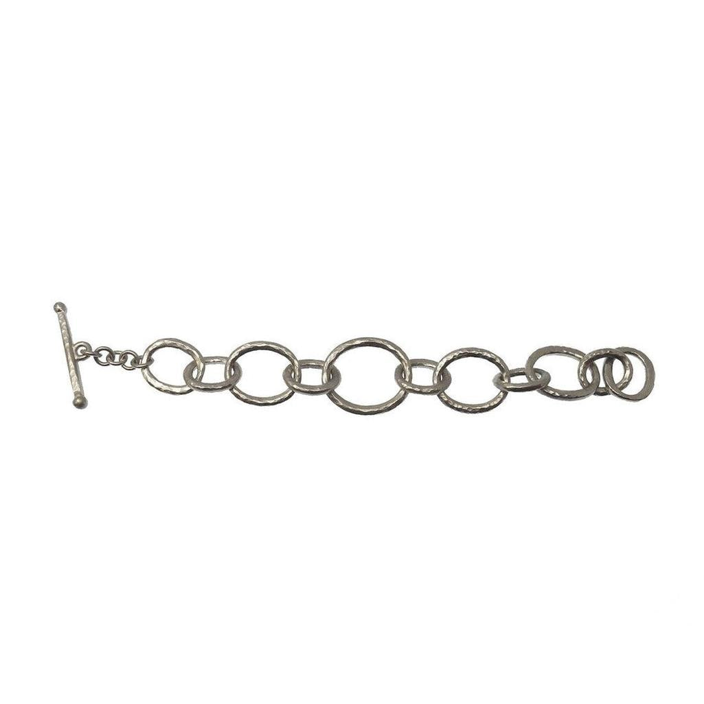 Silver link bracelet with hammered texture and toggle clasp.
