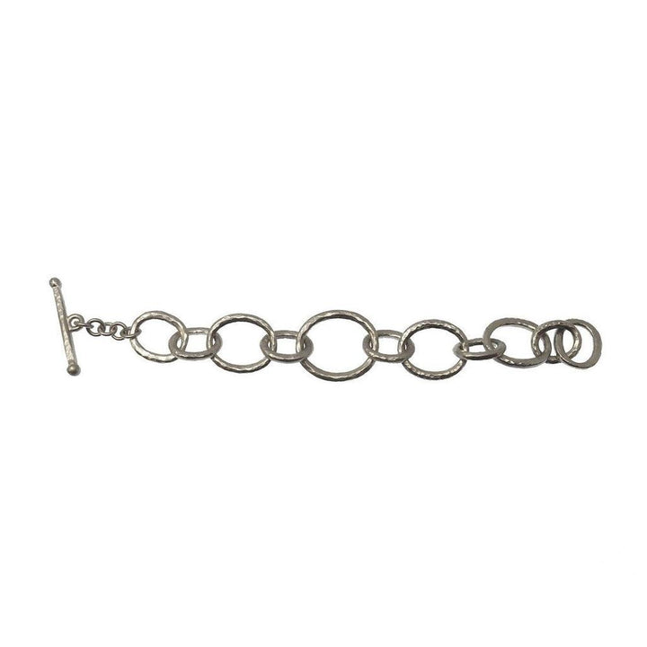 Silver link bracelet with hammered texture and toggle clasp.
