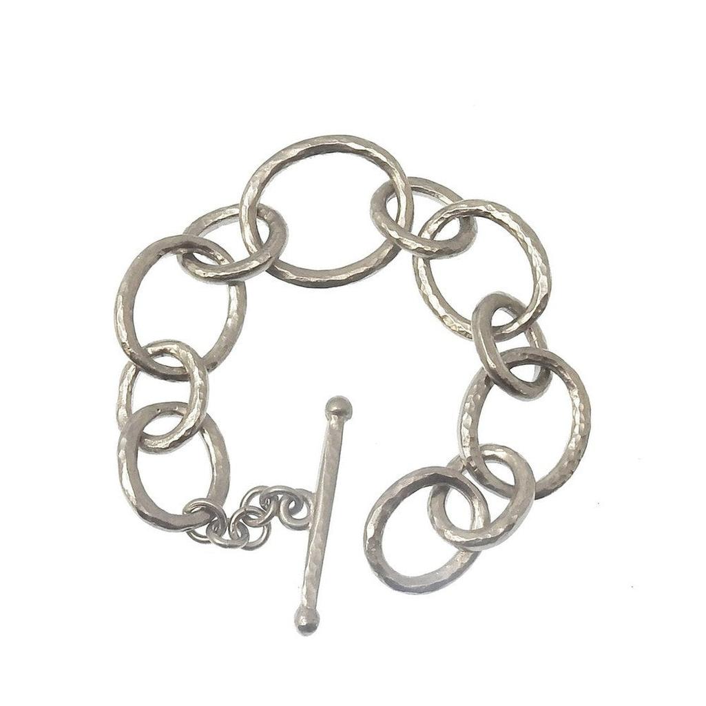 Silver link bracelet with hammered texture and toggle clasp.
