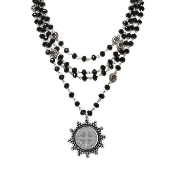 Layered black glass bead necklace with a silver St. Christopher medal pendant.
