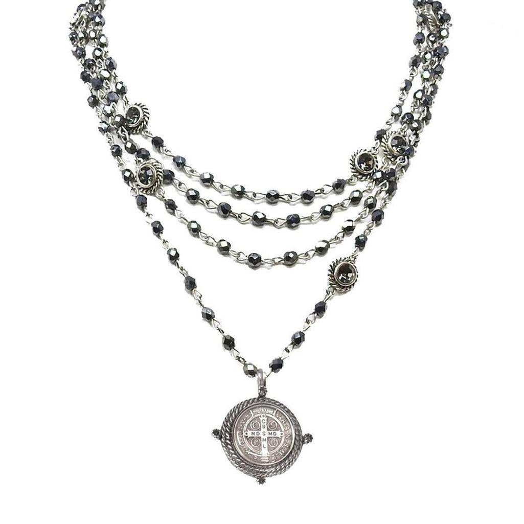 Multi-strand silver necklace with dark gray beads and a detailed pendant.
