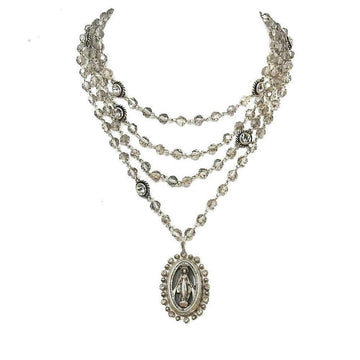 Multi-strand silver necklace featuring faceted beads and a Madonna medallion.
