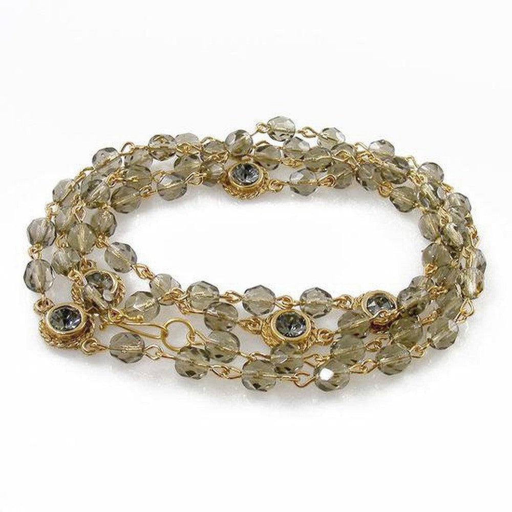 Multi-strand smoky quartz and gold wrap necklace with crystal accents.
