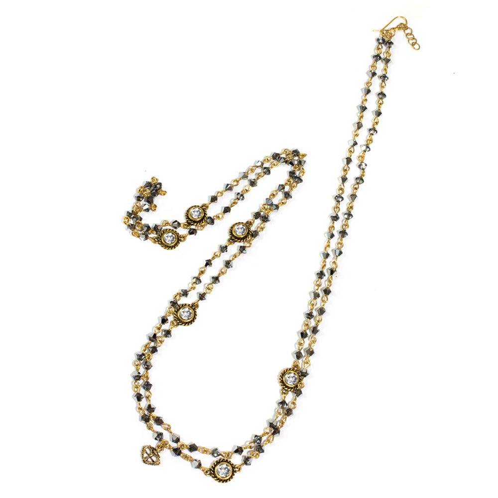 Double-strand beaded necklace with gold accents and clear stones, on white background.
